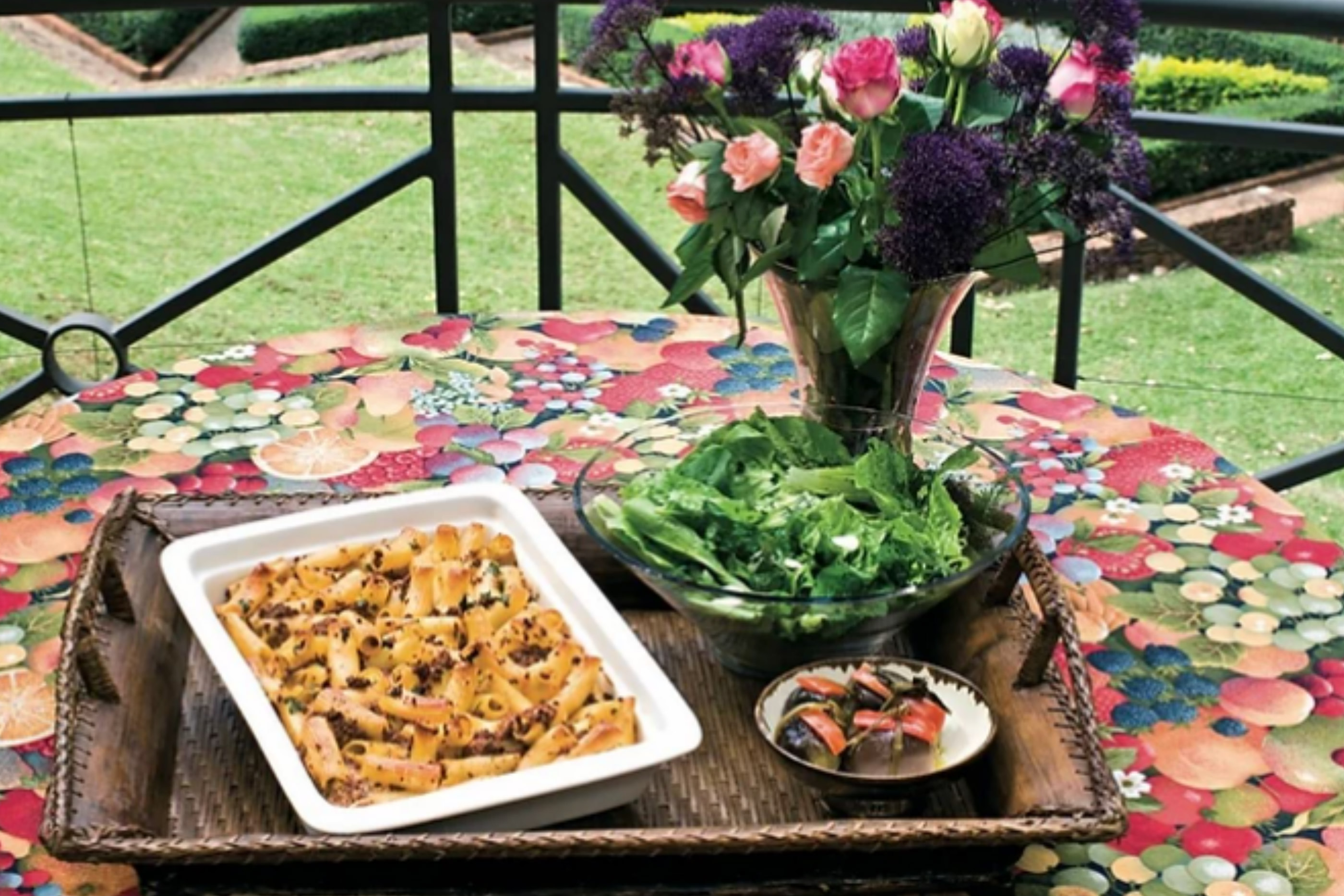 Macaroni and meat bake in a white bowl on a set table outdoors
